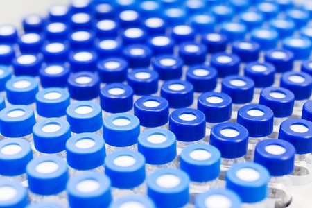 Rows of glass vials in the tray automatic liquid dispenser. Laboratory chemical equipments. Shallow depth of fieldの写真素材