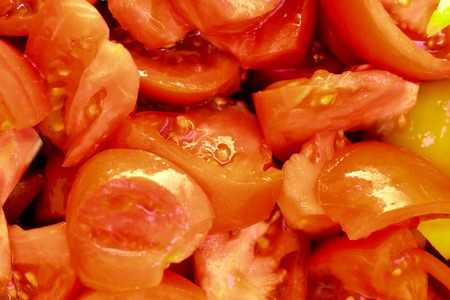Cutting slices of red tomatoes, randomly scattered. Abstract culinary background.の写真素材