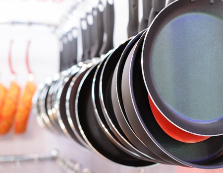 Aluminum non-stick pans. Suspended from each other in a row.の写真素材