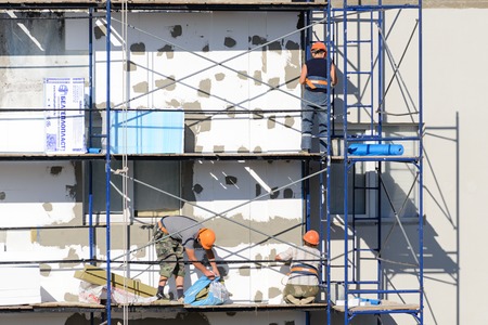 LYAKHOVICHI, BELARUS - AUGUST 28, 2016: Construction workers carry out work on plastering and...