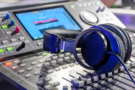 Studio headphones lying on the audio mixer. Live and studio equipment.
