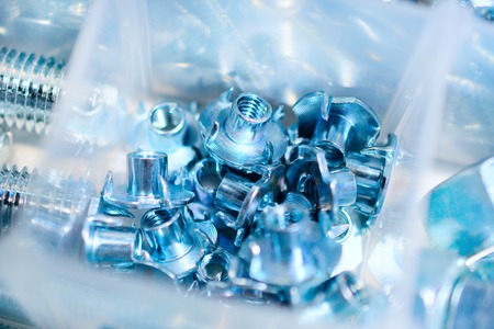 Many screws arranged as background. Metal fasteners, scattered in plastic cells.の写真素材