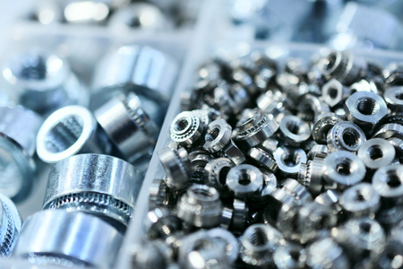 Many screws arranged as background. Metal fasteners, scattered in plastic cells.の写真素材