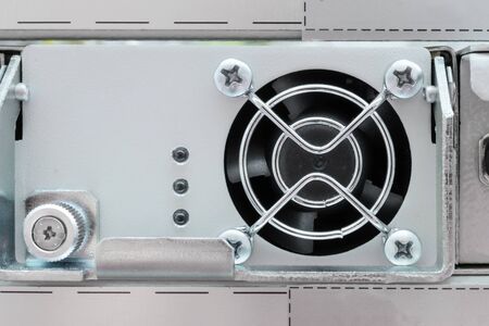 The cooling unit of industrial computer. Electric fan closed shiny metal bars.