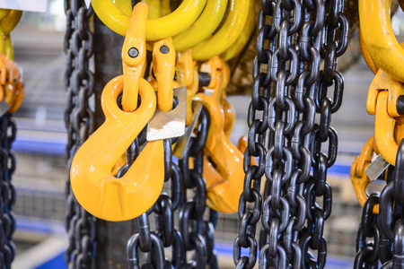 New chain cargo sling. Black steel chain and yellow cargo hooks. Abstract industrial background.の写真素材