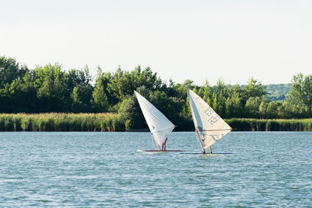 KURCHATOW, RUSSIA - JUNE 23, 2016: Windsurfers are trained on a large lake. Evening shot.のeditorial素材