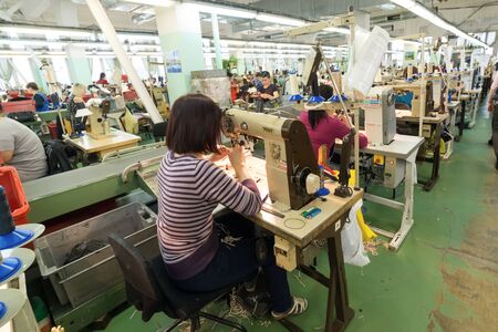 Shoe factory. Female worker on a sewing machine.