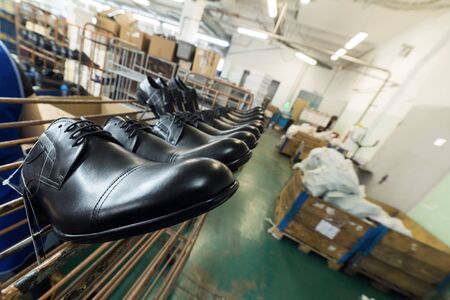 A long line of new black shiny shoes.