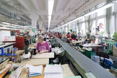 Shoe factory. Female worker on a sewing machine.のeditorial素材