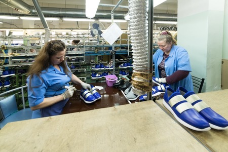 Female workers make shoes at a shoe factory.のeditorial素材