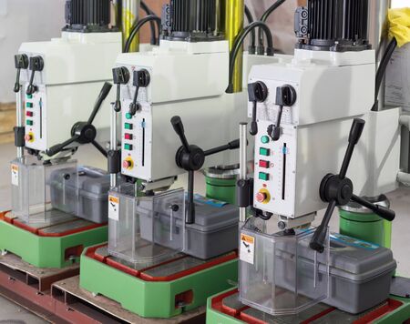 Benchtop vertical drilling machines. The machines are arranged in one row.