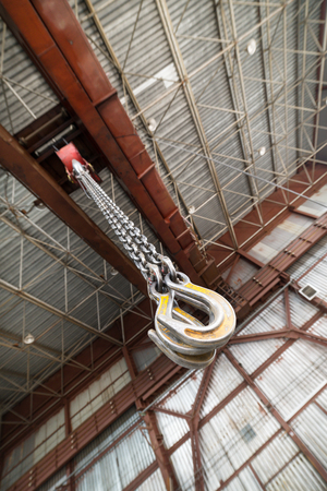 Powerful cargo hooks hang on a long load chain.の写真素材