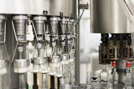 Filling glass bottles with liquid.の写真素材
