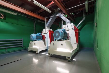 Rotary hammer mills for grinding wheat and barley grain.