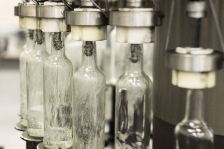 Filling glass bottles with liquid.の写真素材