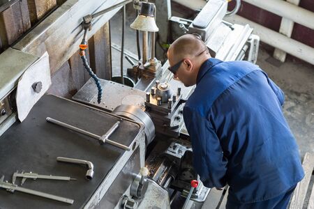 Turning works. The turner makes a metal part on a mechanical lathe.のeditorial素材