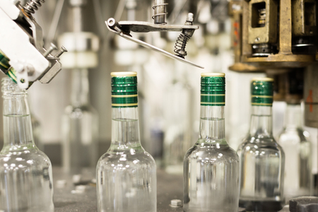 Bottles with a drink closed with a screw cap. Factory for the production of alcoholic beverages.の写真素材
