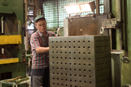 Lipetsk, Russia - June 15, 2017: Lipetsk Machine Tool Plant, The turner operates on a mechanical boring machine. Turning works, metal processing by cutting.のeditorial素材
