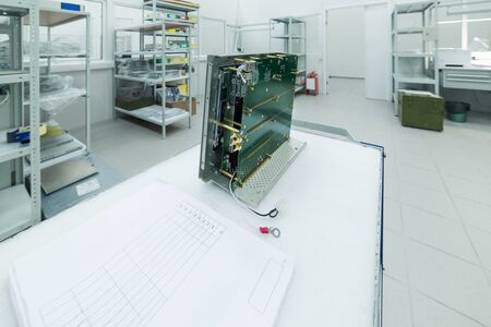 A new electronic module is on the assembly table.