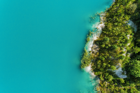 The shores of the mountain lake, the blue water in the lake. Aerial view, from top to bottomの写真素材