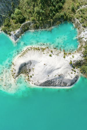 The shores of the mountain lake, the blue water in the lake. Aerial view, from top to bottomの写真素材