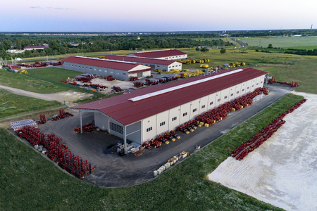 The territory of an industrial plant. Large hangars with a red roof. Aerial view, evening shootingの写真素材
