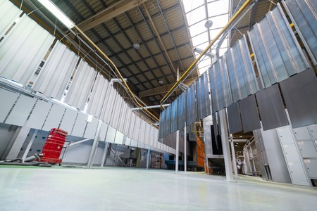 Powder coating line. Metal panels are suspended on an overhead conveyor line.の写真素材