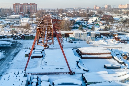 Gantry crane in the warehouse of metal pipes. Sunny winter day.の写真素材