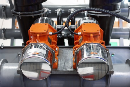 Industrial vibromotors mounted on the pipework of the system of vibrating transportの写真素材
