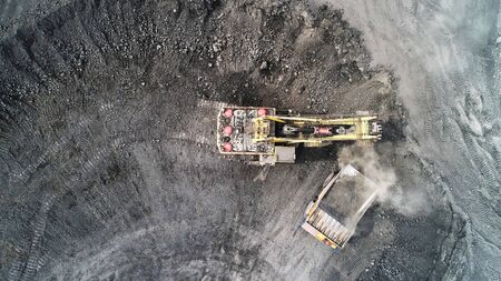 Cable excavator loads overburden from the body of a mining truck.の写真素材