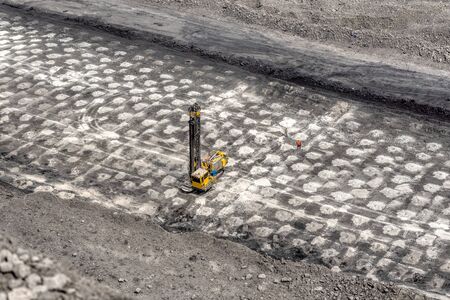 View of a large quarry for the extraction of limestone and coal. The drilling rig makes wells for laying emulsion explosives. Preparing a ledge quarry for an explosion.の写真素材