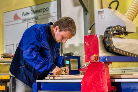 A worker measures a part made on a milling machine. Stage control of finished products.のeditorial素材