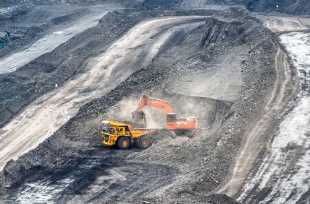 Coal mining in a quarry. A hydraulic excavator loads a dump truck.
