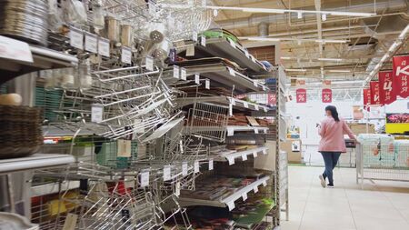 The buyer with a grocery cart moves around the supermarket. A modern large and spacious store.のeditorial素材