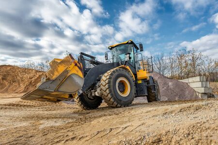 Wheel loader rides on a construction site. Special construction equipment for earthmoving and...