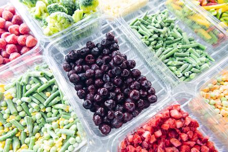 Frozen Cherry Berries. Freezing vegetables and fruits. Food products are poured into rectangular...