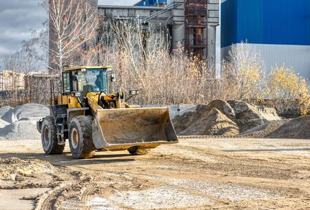 Wheel loader rides on a construction site. Special construction equipment for earthmoving and...