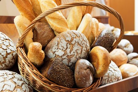 Fresh baked bread. A lot of bread lies in a wooden wicker basket.の写真素材