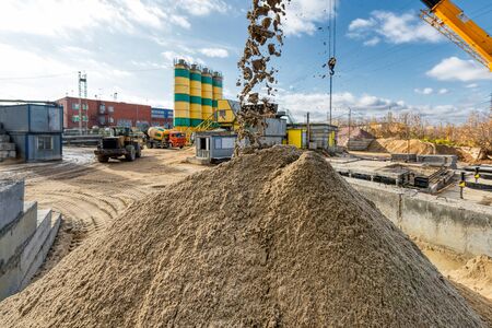 A conveyor belt spills a large pile of sand. Extraction and storage of building materials.の写真素材