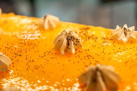 Cream curls on a big yellow cake. Confectionery decorations. Close-up shot.の写真素材