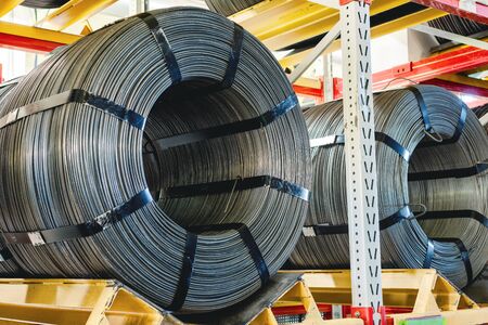 Factory stock wire. Wire spools lie on multi-tiered racks.の写真素材