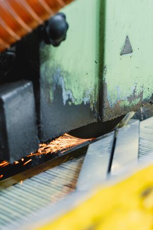 Work of an industrial surface grinding machine. Grinding of a flat metal part.