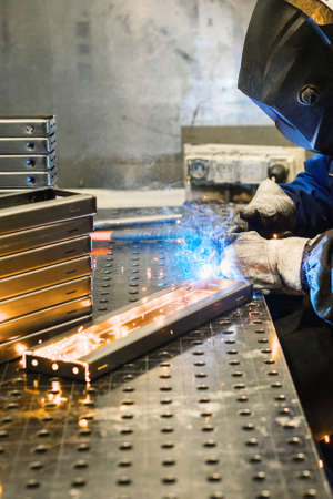 Working welder welds parts factory