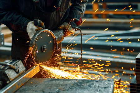 Cutting a metal beam using an electric hand saw.の写真素材