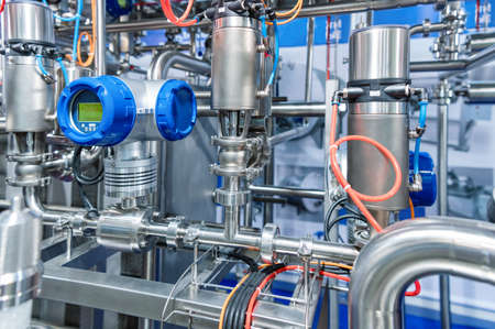 Industrial stainless steel piping connected by special nuts.