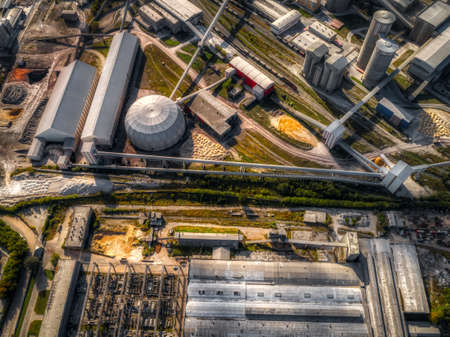 Large plant, aerial view. Many vertical towers, warehouses.