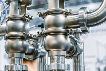 Industrial stainless steel piping connected by special nuts.の写真素材
