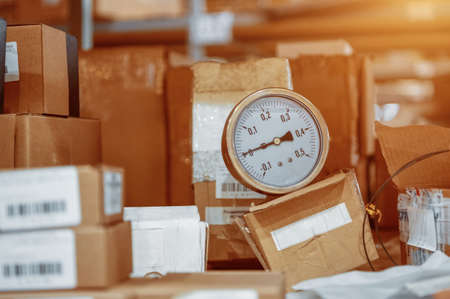 The pressure gauge lies in the middle of the cardboard boxes.の写真素材