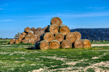 The straw bales are stacked in a large pile.