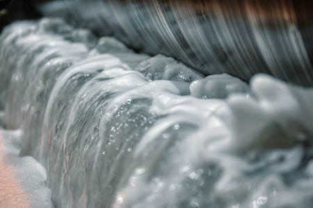 Metal drum of magnetic separator, bubbling and foaming water.の写真素材